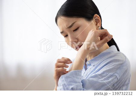 辛そうな表情で手を掻く日本人女性 辛そうな表情で手を掻く日本人女性 139732212