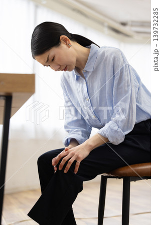 膝に手を当てて痛そうな表情をする日本人女性 139732285