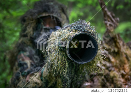 Wildlife photographer in the summer ghillie camouflage suit Wildlife photographer in the summer ghillie camouflage suit 139732331