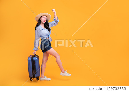 Happy Asian woman traveler standing and holding suitcase isolated on yellow background, Tourist girl having cheerful holiday trip concept, Full body composition. Happy Asian woman traveler standing and holding suitcase isolated on yellow background, Tourist girl having cheerful holiday trip concept, Full body composition. 139732886
