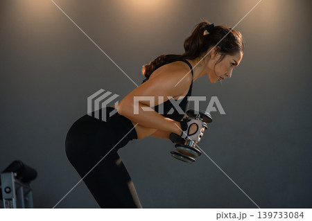 Fitness asian woman doing exercise and lifting dumbbells weights at sport gym. 139733084