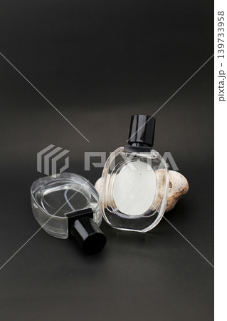 Elegant Three Glass Perfume Bottles Against a Minimalist Dark Background. Elegant Three Glass Perfume Bottles Against a Minimalist Dark Background. 139733958