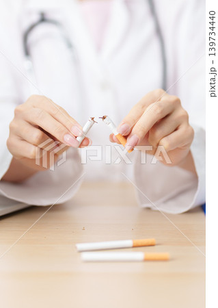doctor hand making stop sign to refuse and breaking cigarette, quitting smoking for healthy lungs, prevent Lung Cancer and Emphysema, World No Tobacco Day concept 139734440