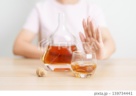 woman making stop hand gesture to refuse a glass of Cognac, Healthy man say no to alcohol drink, stop alcoholism and addiction concept. Responsible man reject a drink before driving and quit booze 139734441
