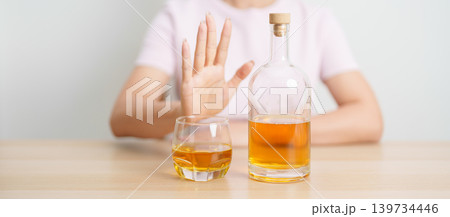 woman making stop hand gesture to refuse a glass of whiskey, Healthy man say no to alcohol drink, stop alcoholism and addiction concept. Responsible man reject a drink before driving and quit booze woman making stop hand gesture to refuse a glass of whiskey, Healthy man say no to alcohol drink, stop alcoholism and addiction concept. Responsible man reject a drink before driving and quit booze 139734446