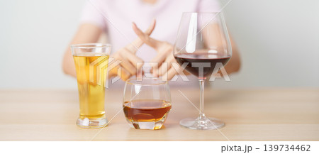 woman stop hand gesture to refuse a glass of wine, beer, whiskey or cognac on table. say no to alcohol drink, stop alcoholism addiction, Responsibility, reject a drink before drive and quit booze woman stop hand gesture to refuse a glass of wine, beer, whiskey or cognac on table. say no to alcohol drink, stop alcoholism addiction, Responsibility, reject a drink before drive and quit booze 139734462