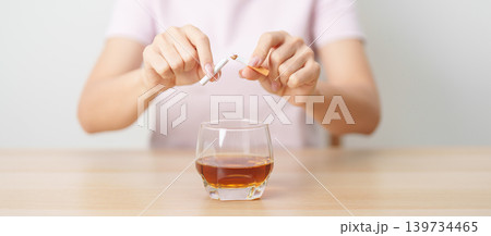 woman hand break and stop gesture to refuse cigarette and glass of Whisky, for say no to alcohol drink and for World No Tobacco Day, quitting smoking to prevent Lung Cancer and stop nicotine addiction woman hand break and stop gesture to refuse cigarette and glass of Whisky, for say no to alcohol drink and for World No Tobacco Day, quitting smoking to prevent Lung Cancer and stop nicotine addiction 139734465