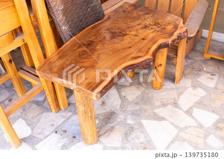 Rustic wooden table with unique shape and natural finish in workshop Rustic wooden table with unique shape and natural finish in workshop 139735180