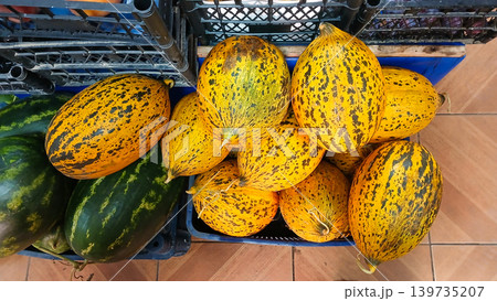 Top view fresh yellow melons with spotted skin displayed in market baskets 139735207