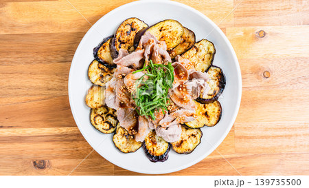 木目テーブルの上に置かれた焼きなすの豚しゃぶのせ 木目テーブルの上に置かれた焼きなすの豚しゃぶのせ 139735500