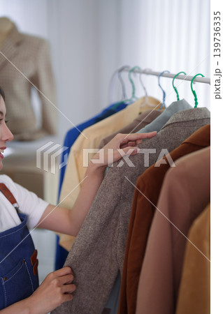 Asian women online merchant live streaming fashion clothing selection for ecommerce social media business selling apparel product showcase from home studio Asian women online merchant live streaming fashion clothing selection for ecommerce social media business selling apparel product showcase from home studio 139736335