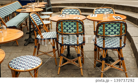 Empty parisian cafe terrace with bistro tables and woven rattan chairs, ready for customers in France Empty parisian cafe terrace with bistro tables and woven rattan chairs, ready for customers in France 139737292