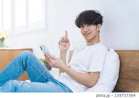 リラックスしてスマホを使う男性 139737364