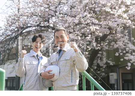 桜の前でガッツポーズする男性作業員のグループ 桜の前でガッツポーズする男性作業員のグループ 139737406