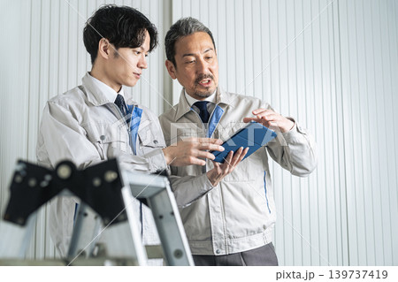 打ち合わせする男性作業員のグループ 打ち合わせする男性作業員のグループ 139737419