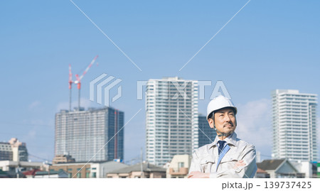 都市の前で遠くを眺める男性作業員 139737425