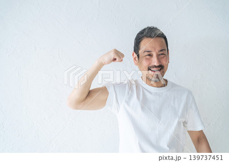 力こぶを見せるミドルエイジ男性 139737451