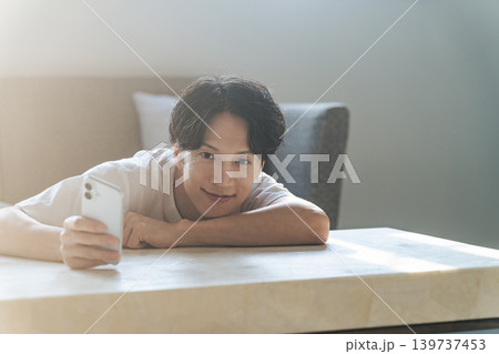 笑顔でスマホを使う男性 139737453
