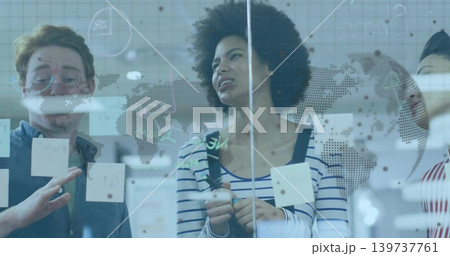 Holding marker, woman with curly hair in striped top marking office glass with stickies, dotted map Holding marker, woman with curly hair in striped top marking office glass with stickies, dotted map 139737761