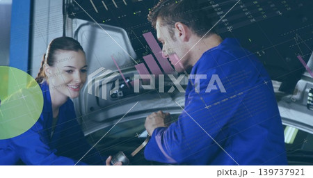 Leaning techs in blue coveralls inspecting open trunk at bay, holding wrench, data overlays 139737921