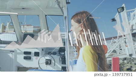 Standing teenage girl yellow top peering into motorboat helm at marina, digital charts, copy space 139737951