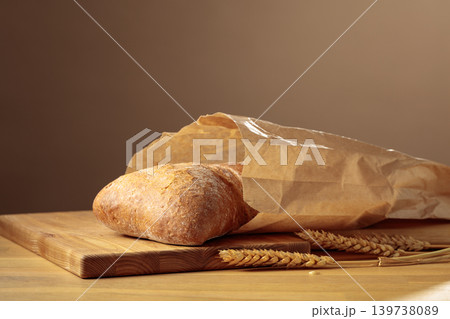Fresh backed ciabatta bread in paper bag on a wooden table. Fresh backed ciabatta bread in paper bag on a wooden table. 139738089