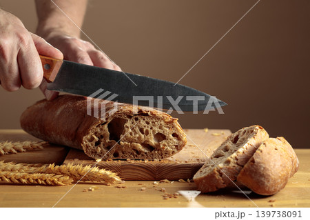The chef is slicing freshly baked bread. The chef is slicing freshly baked bread. 139738091