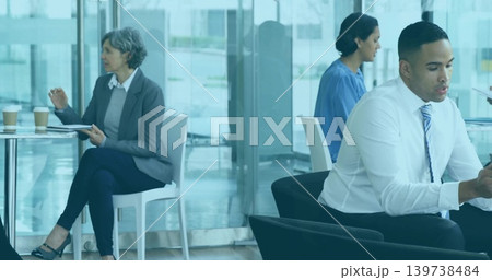 Checking businessman in white shirt, striped-tie scrolling phone in office lobby, with takeout cups Checking businessman in white shirt, striped-tie scrolling phone in office lobby, with takeout cups 139738484