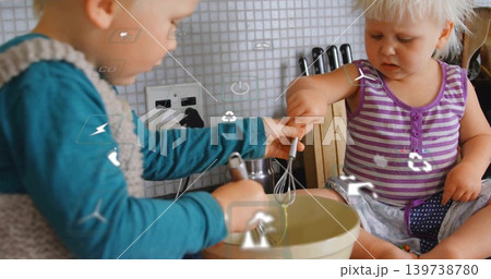 Stirring children in teal vest and purple striped top at kitchen counter, mixing bowl and whisks Stirring children in teal vest and purple striped top at kitchen counter, mixing bowl and whisks 139738780