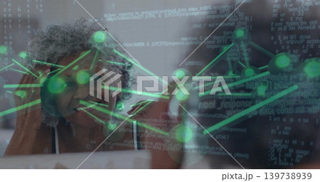 Leaning senior woman wearing top and necklace, gazing at window at home with green nodes, code Leaning senior woman wearing top and necklace, gazing at window at home with green nodes, code 139738939