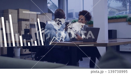 Talking coworkers gesturing at office table in blue shirt, dark blazer, laptop showing data overlay Talking coworkers gesturing at office table in blue shirt, dark blazer, laptop showing data overlay 139738995