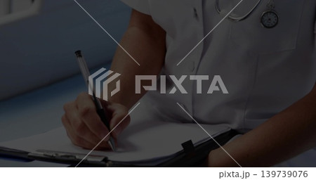 Writing mid-adult clinician filling patient form in clinic wearing white medical top and clipboard Writing mid-adult clinician filling patient form in clinic wearing white medical top and clipboard 139739076