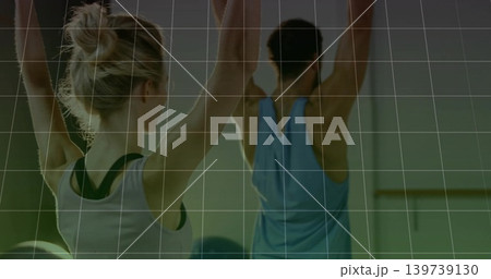 Stretching woman in white tank dark-straps and man in blue top, studio, ball mirror barre grid Stretching woman in white tank dark-straps and man in blue top, studio, ball mirror barre grid 139739130