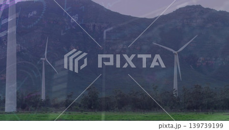 Standing three white turbines dominating mountain base at rural wind farm, with faint GUI overlay Standing three white turbines dominating mountain base at rural wind farm, with faint GUI overlay 139739199