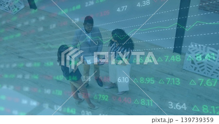 Standing three staff in suits reviewing tablet, folder on wood floor, planter and market overlay 139739359
