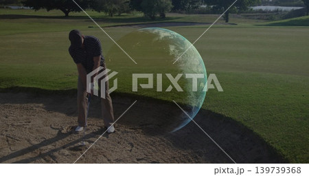 Preparing golfer in golf attire lining up iron shot in bunker with Earth-like hologram, copy space Preparing golfer in golf attire lining up iron shot in bunker with Earth-like hologram, copy space 139739368