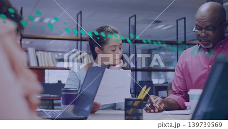 Holding printed document and resting chin, professional reviewing at open office table with laptops Holding printed document and resting chin, professional reviewing at open office table with laptops 139739569