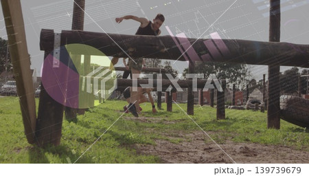 Jumping male athlete in athletic wear clearing wooden beam at park with tires and overlay graphic 139739679