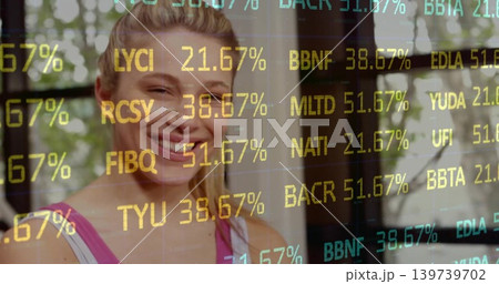 Smiling woman wearing pink tank top with white strap in home studio window, showing ticker overlay Smiling woman wearing pink tank top with white strap in home studio window, showing ticker overlay 139739702