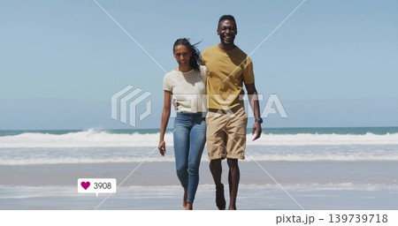 Walking adult couple embracing along wet shoreline at beach, casual clothes, heart 3908, wristwatch Walking adult couple embracing along wet shoreline at beach, casual clothes, heart 3908, wristwatch 139739718