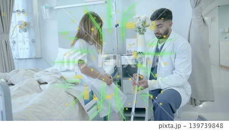 Examining doctor wearing coat and stethoscope, holding crutch beside child in gown on hospital bed Examining doctor wearing coat and stethoscope, holding crutch beside child in gown on hospital bed 139739848