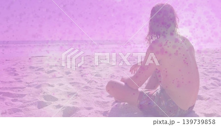 Sitting man watching pink sea glare at sandy beach with prints, patterned swim trunks, copy space Sitting man watching pink sea glare at sandy beach with prints, patterned swim trunks, copy space 139739858