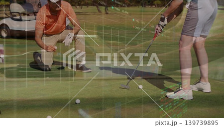 Putting woman in shorts, kneeling partner lining up putt on green with golf balls, market data 139739895