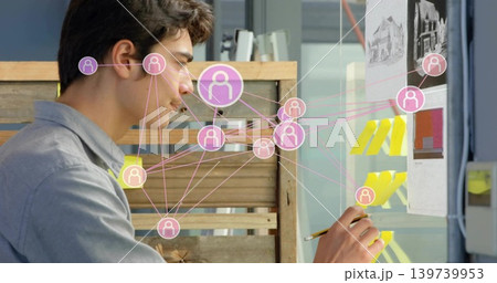 Arranging designer in gray shirt organizing yellow notes on glass board at studio with pink overlay 139739953