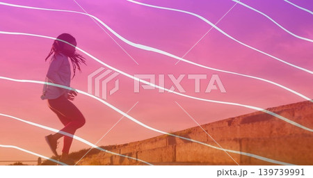 Leaping woman on concrete ledge at dusk in sportswear, shoes, grassy slope, wavy lines, copy space Leaping woman on concrete ledge at dusk in sportswear, shoes, grassy slope, wavy lines, copy space 139739991