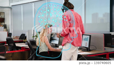 Talking pair in business wear holding phone, viewing charts with blue brain graphic at office desk Talking pair in business wear holding phone, viewing charts with blue brain graphic at office desk 139740605