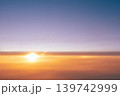 Beautiful sunset and the sun above the clouds - the view from the plane to the evening sky. Beautiful background for airlines and air travel copy space. High quality photo 139742999