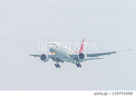 Mai Khao Phuket Thailand 2025 11 25: Nordwind Airlines Boeing 777-200ER prepares to land over Mai Khao Beach, approaching Phuket Airport in Thailand on a clear day with a blue sky. High quality photo 139743000
