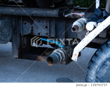 Close up of a water discharge valve and pipeline system underneath a water tanker truck. Close up of a water discharge valve and pipeline system underneath a water tanker truck. 139743737