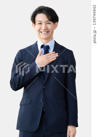 胸に手を当てて立つ男性ビジネスマン 胸に手を当てて立つ男性ビジネスマン 139744842
